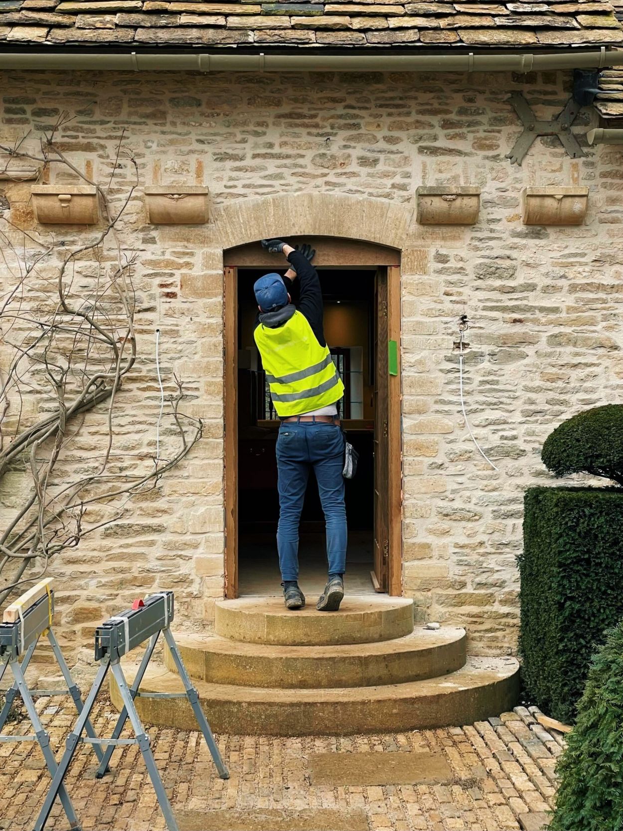 Man in high-viz vest working on an exterior door.